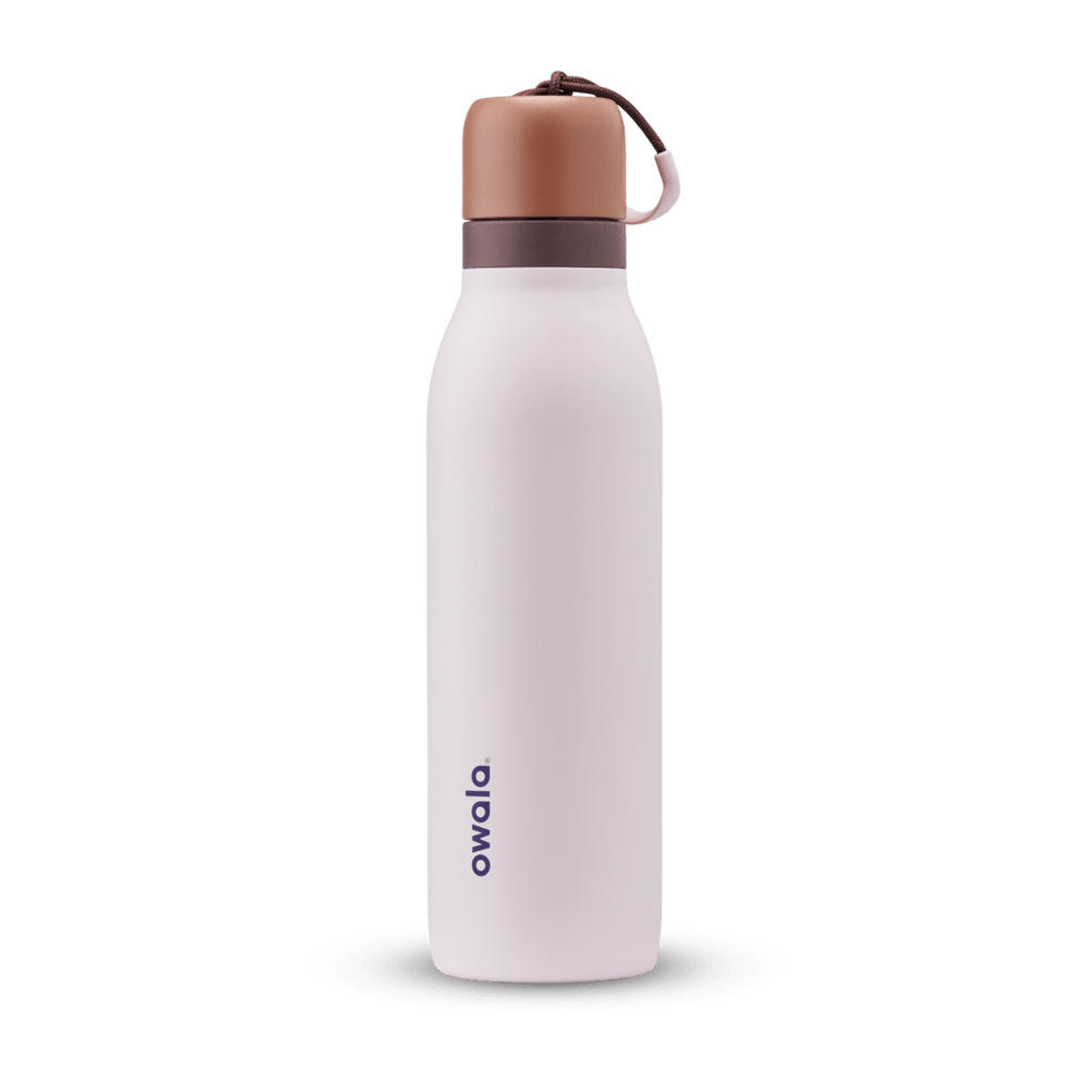 FreeSip Twist 18oz in Sleepy Lavender, soft pale lavender insulated water bottle with copper-orange twist cap, dark plum twist cap accent band, and pink carry string with brown grip